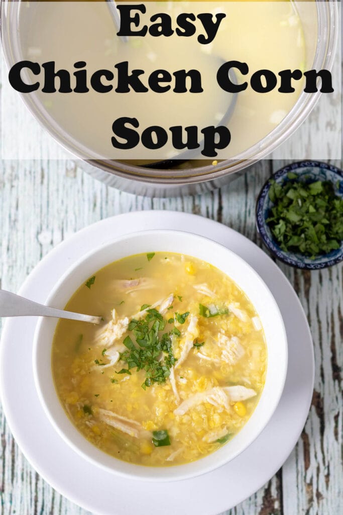 Birds eye view of a bowl of the best easy to make chicken corn soup garnished with parsley and a soup spoon in. Pin title text overlay at top.