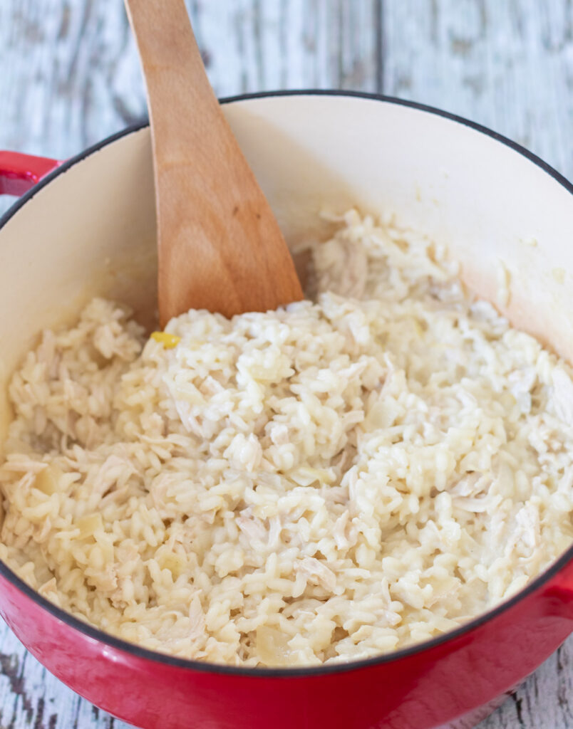 Cooked chicken and cream cheese stirred into casserole pot of cooked rice.
