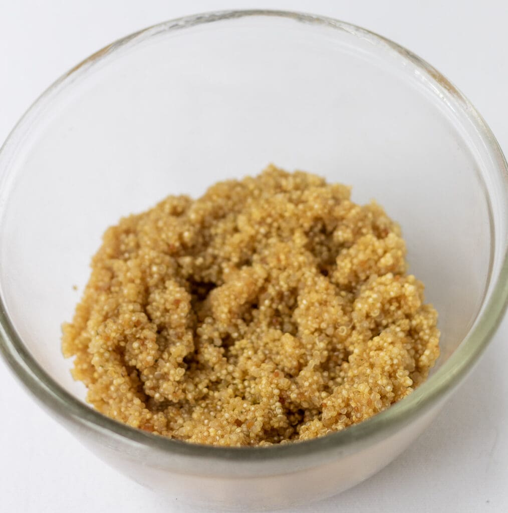 Drained cooked quinoa in a small bowl.