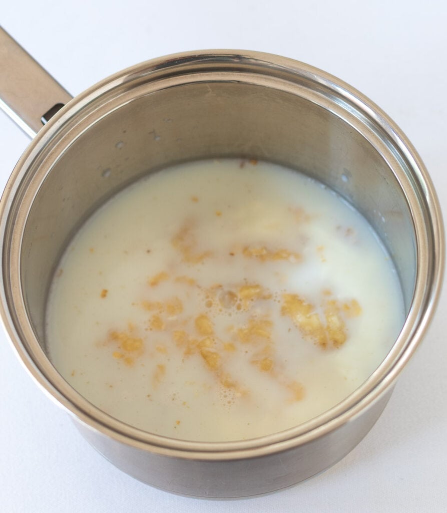 Oats, milk, Greek yogurt and banana in a small saucepan.