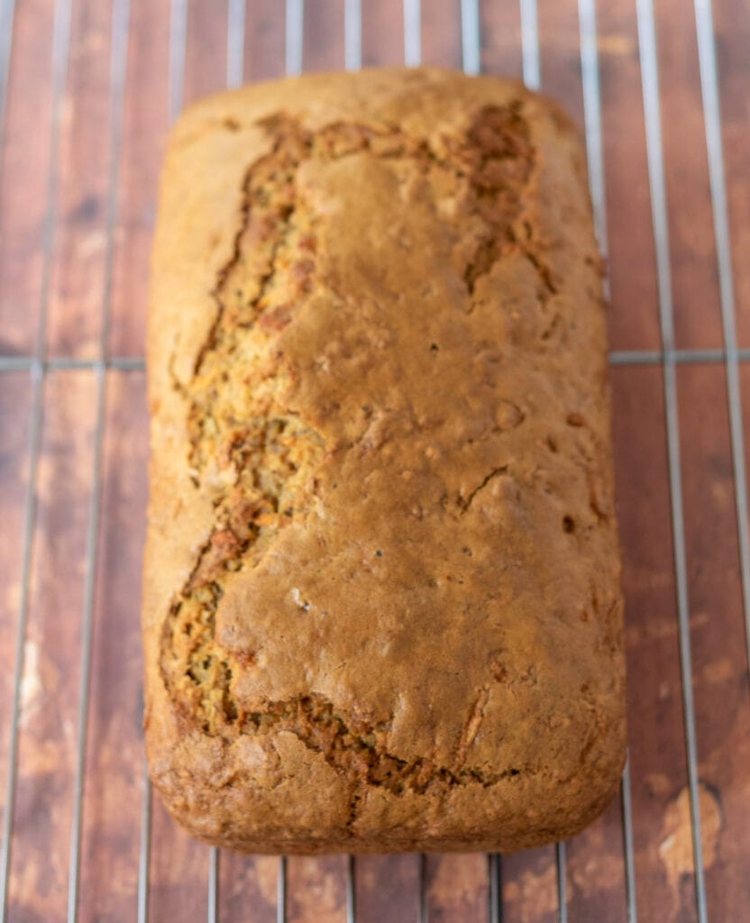 Carrot cake loaf removed from loaf tin and cooling on a wire baking rack.
