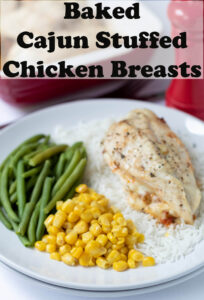 Plated baked Cajun stuffed chicken breast served on a bed of rice with green beans and sweetcorn as accompaniment. Pin title text overlay at top.