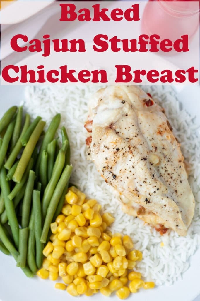 Overhead view of a plate with baked cajun stuffed chicken breast on a bed of white rice alongside sweetcorn and green beans.