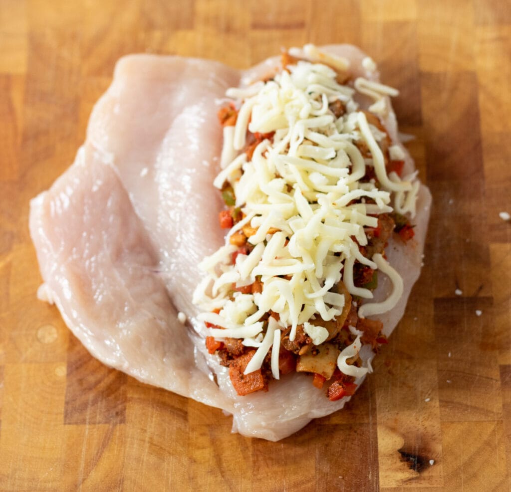 Split chicken breast topped with Cajun mushroom pepper mixture and topped with grated mozzarella.