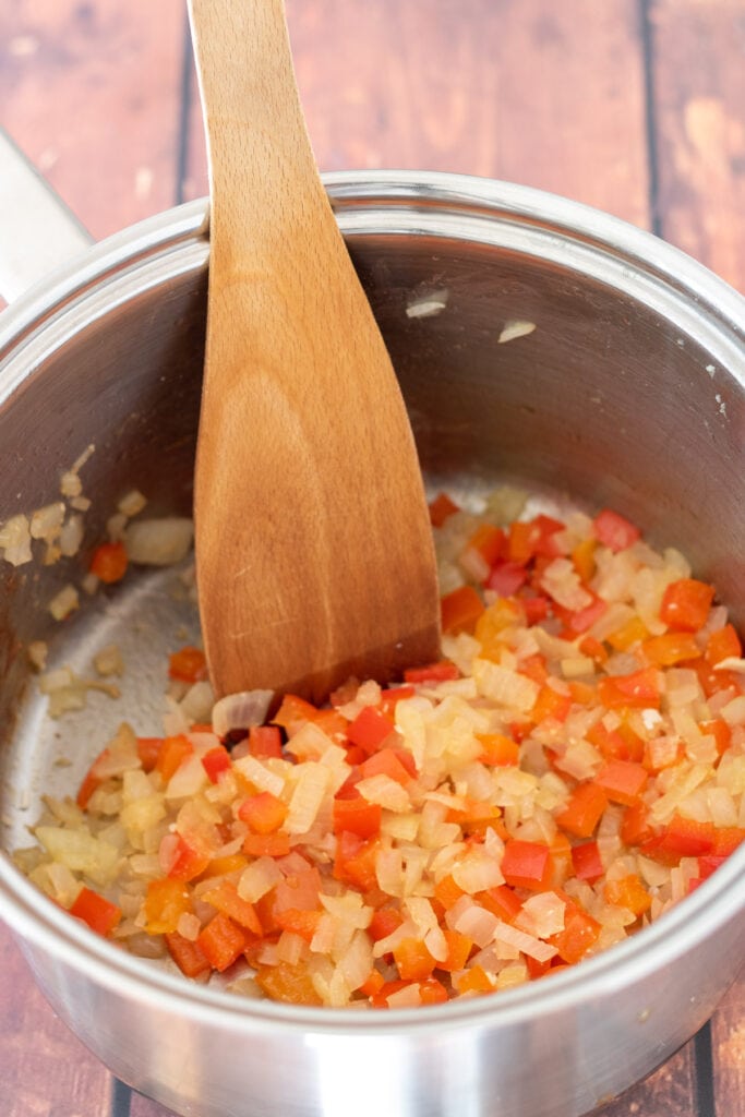 Onion and red pepper sauteed in a large saucepan.