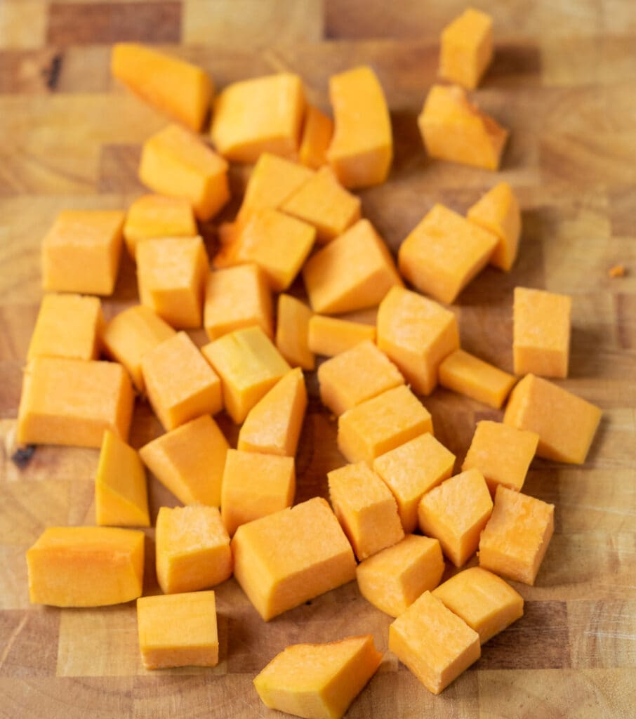 Cubes of butternut squash on a chopping board.