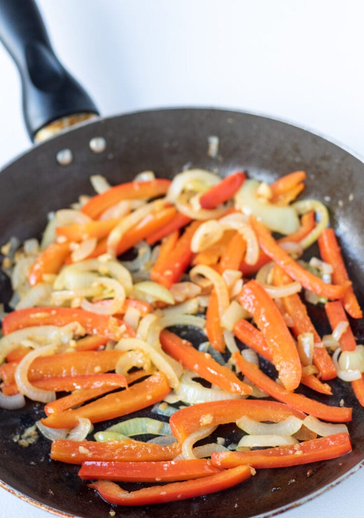 Onion, garlic, and red pepper sautéd together in a pan.