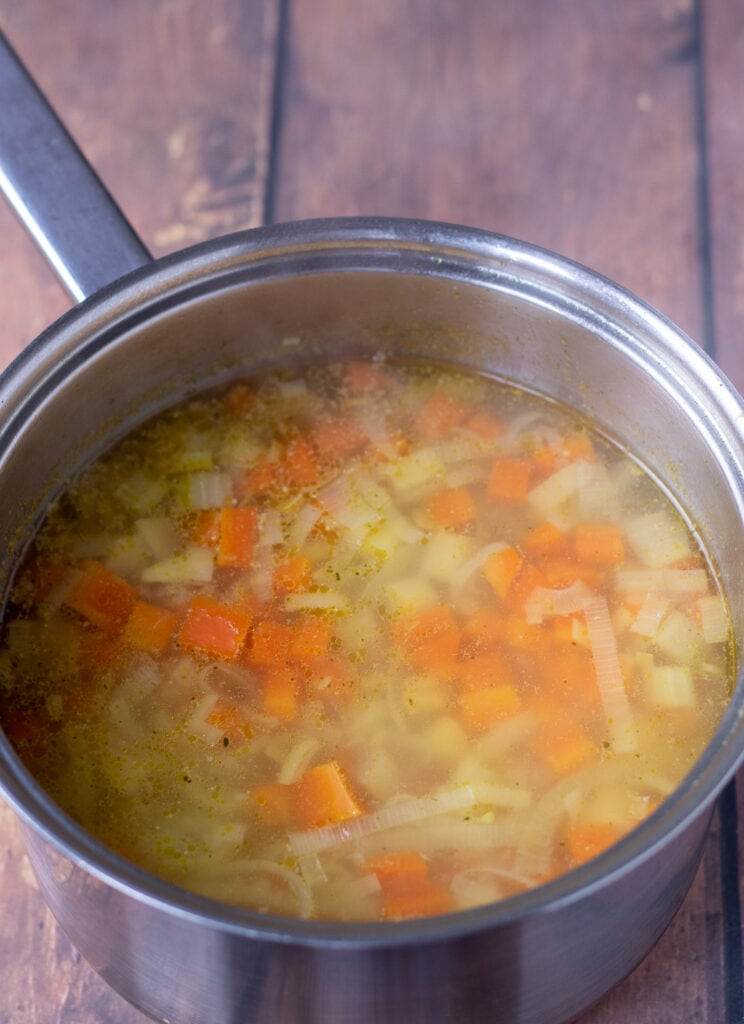 Large soup pot containing softened cooked soup vegetables.