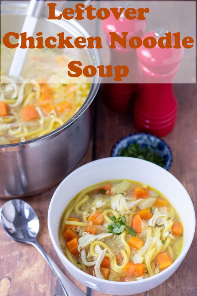 Leftover chicken noodle soup served in a white bowl with a soup spoon beside. To the right salt and pepper cellars. Pin title text overlay at top.