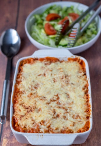A delicious serving of Easy Tomato Tuna Pasta Bake with melted cheese and fresh herbs