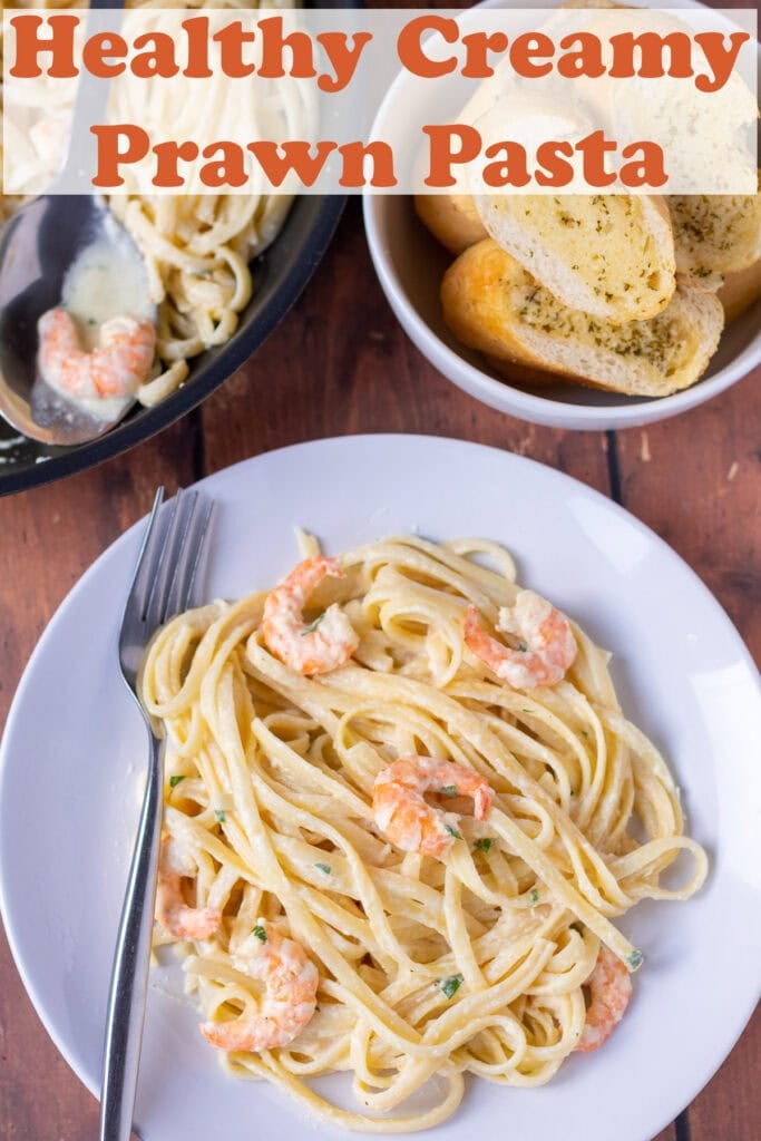 Overhead view of a plate of healthy creamy prawn pasta with a fork beside it. Pin title text overlay at top.