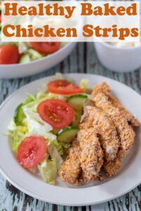 A plate of healthy baked chicken strips served alongside a side salad. Pin title text overlay at top.