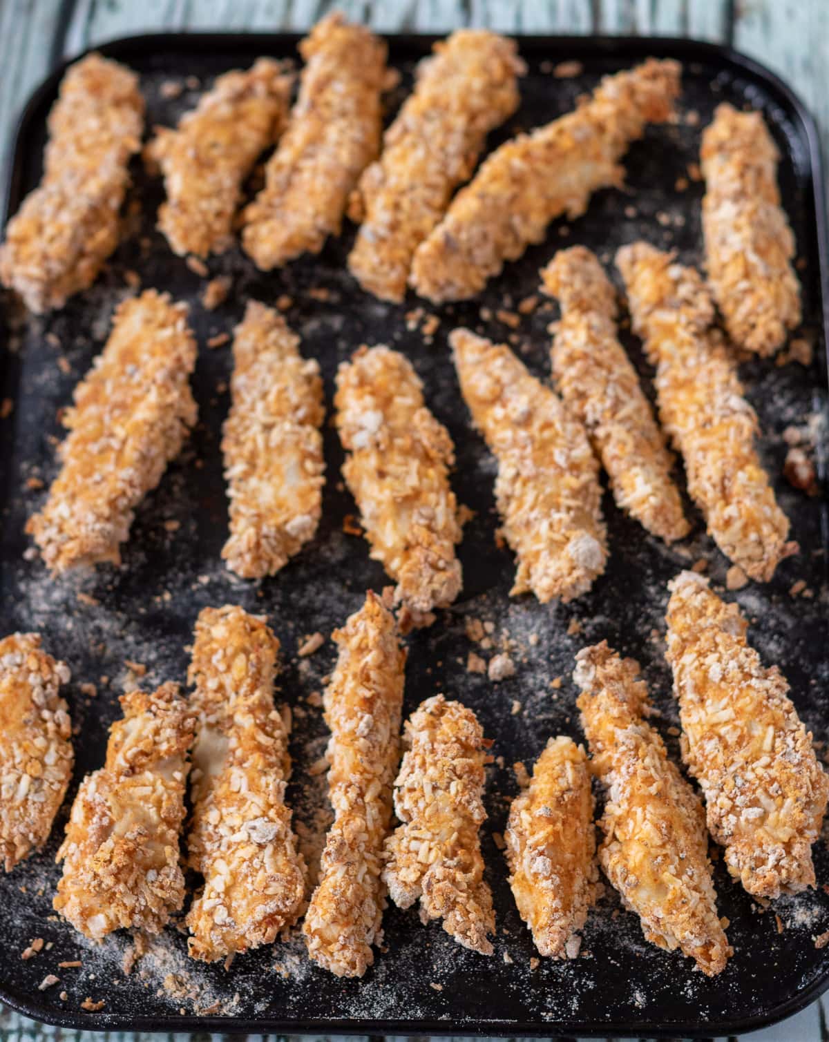 Healthy baked chicken strips on a baking tray cooked and removed from the oven.
