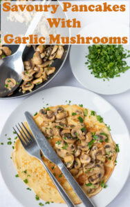 Savoury pancakes with garlic mushrooms served on a plate with a knife and fork to the side. Pin title text overlay at top.