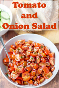 A bowl of tomato and onion salad with a serving spoon in. Pin title text overlay at top.