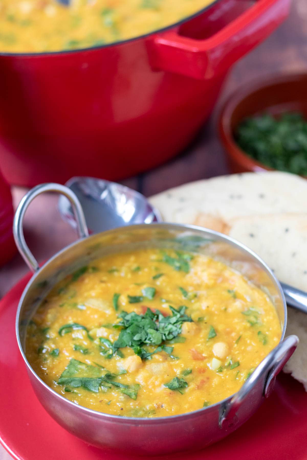 Close up of chickpea lentil curry served in a balti dish garnished with chopped coriander.