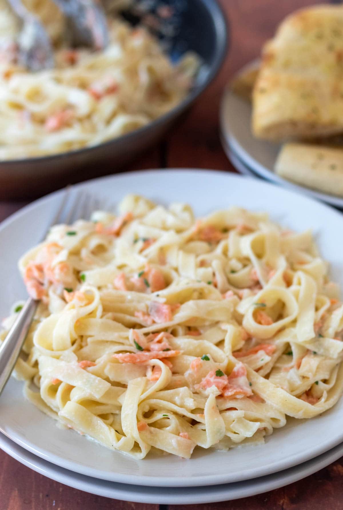 Creamy healthy salmon pasta served on a plate with a fork to the side.