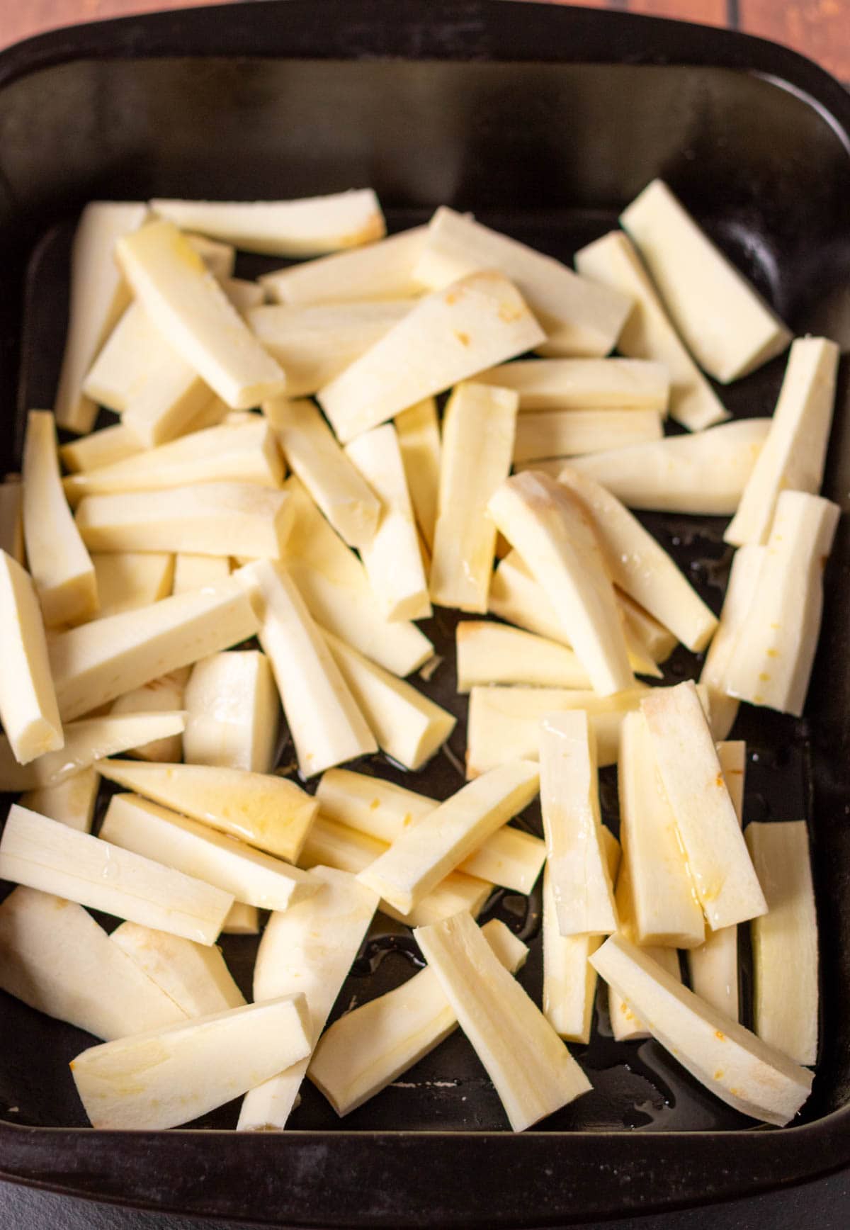 Parsnips cut up into baton shapes and placed in a roasting tin with sunflower oil and honey drizzled over.