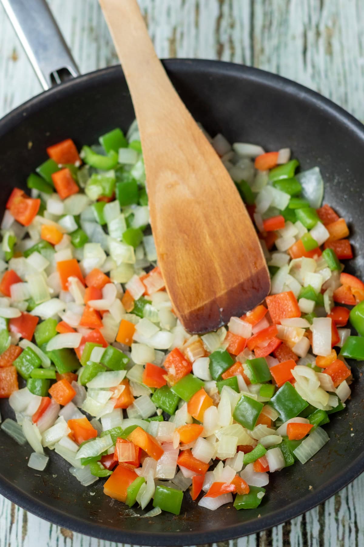 Onion, garlic, red and green peppers sauted in a pan.