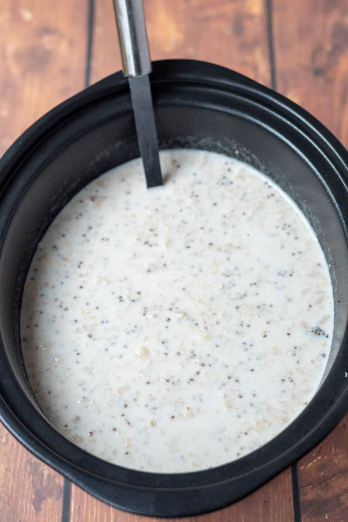 Parially cooked slow cooker banana porridge in slow cooker.