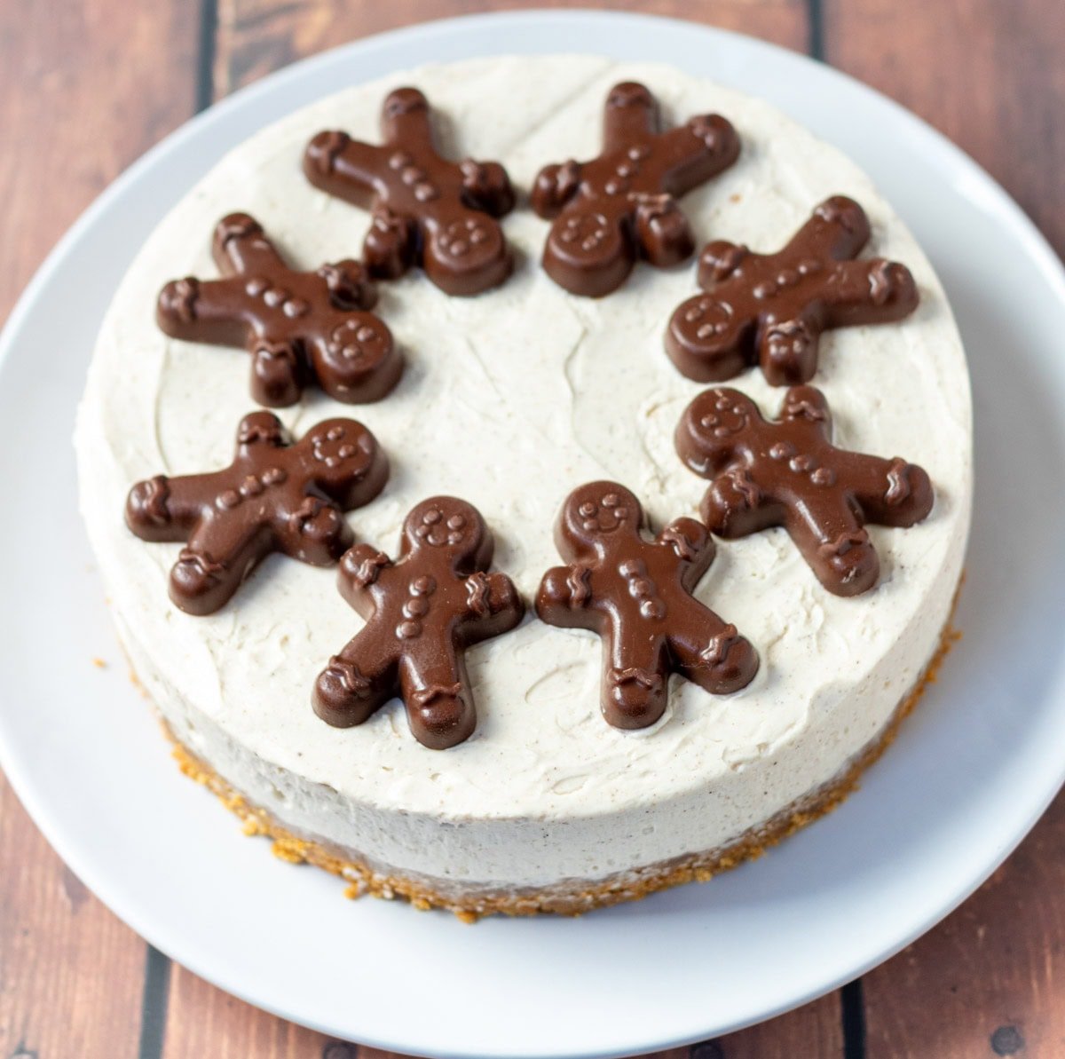 Easy no-bake gingerbread cheesecake decorated with 8 chocolate gingerbread biscuits in a circle.