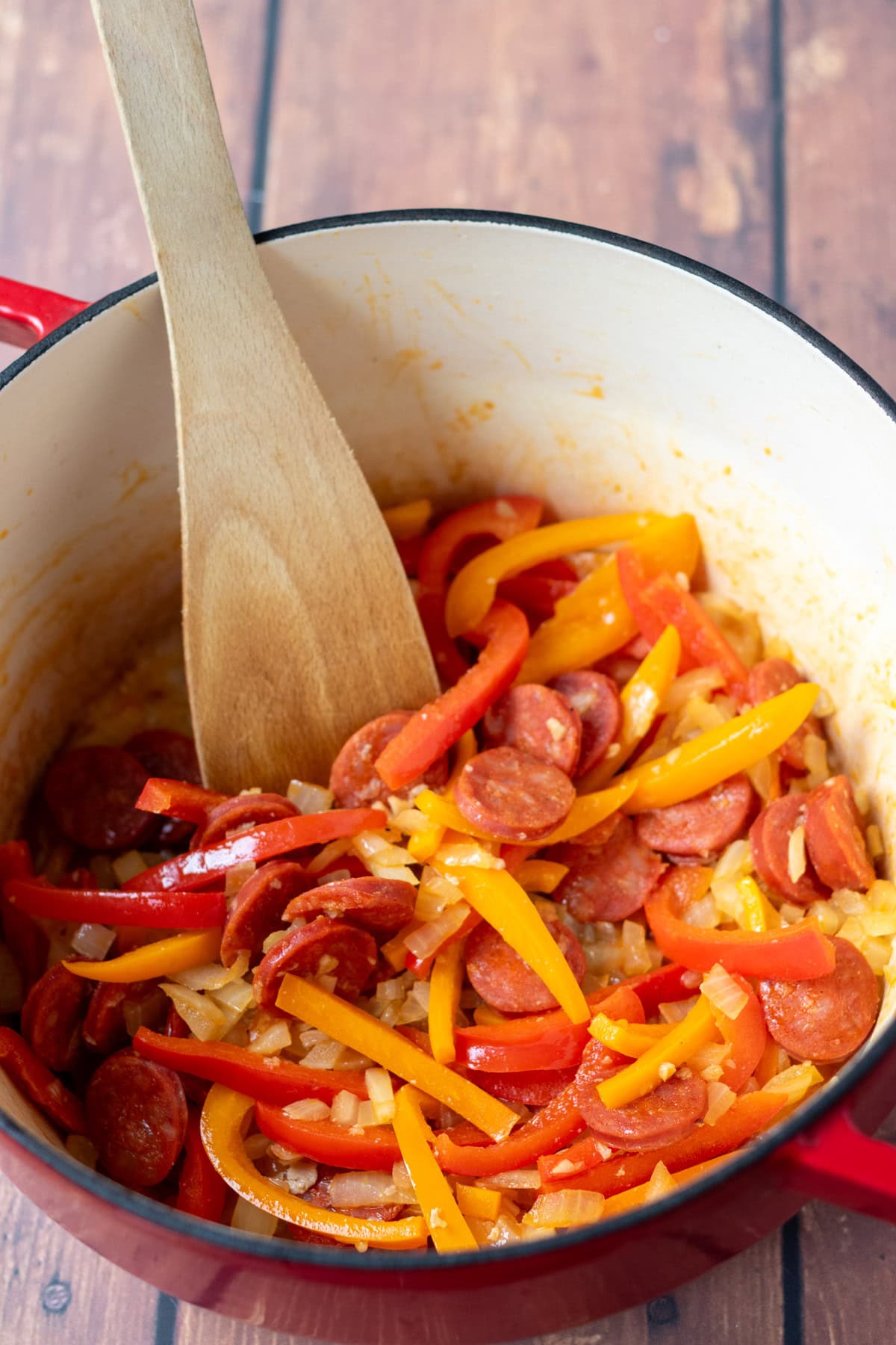 Onion, peppers and garlic added to slices of cooked chorizo and cooked in a large casserole pot.