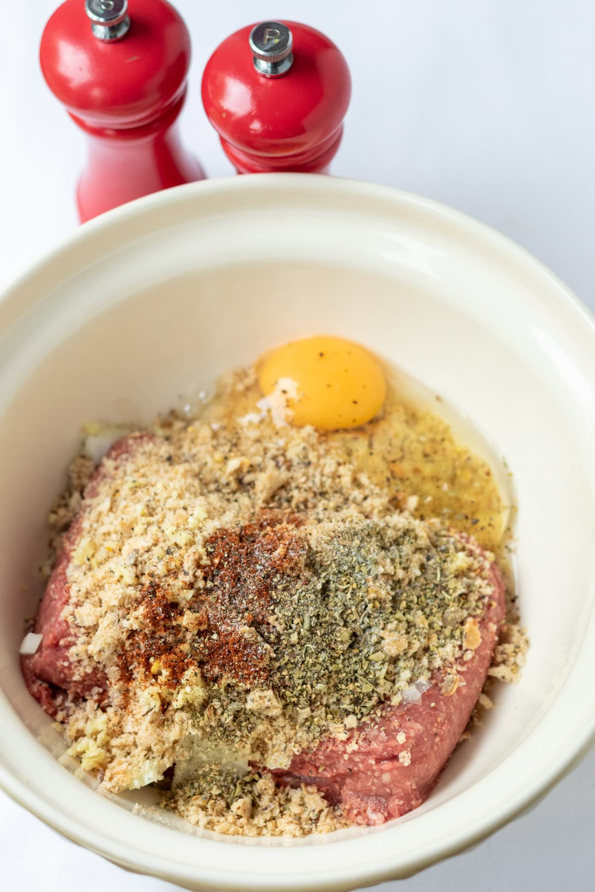 Lamb mince, breadcrumbs, onion, garlic, egg and oregano and chilli powder in a large mixing bowl seasononed with salt and black pepper.