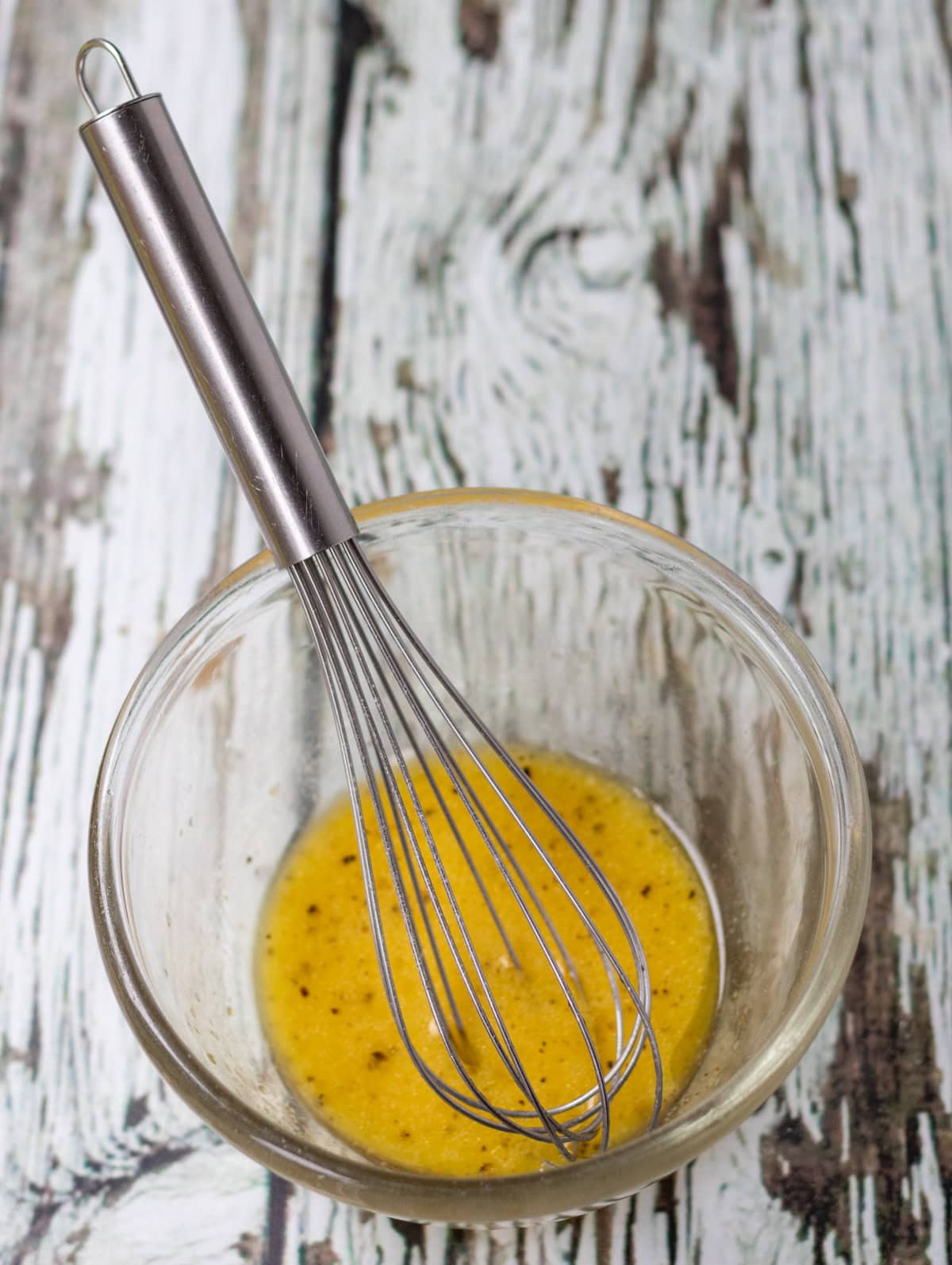 Olive oil, lemon juice, Dijon mustard, salt and pepper in a small pyrex mixing bowl with a whisk.