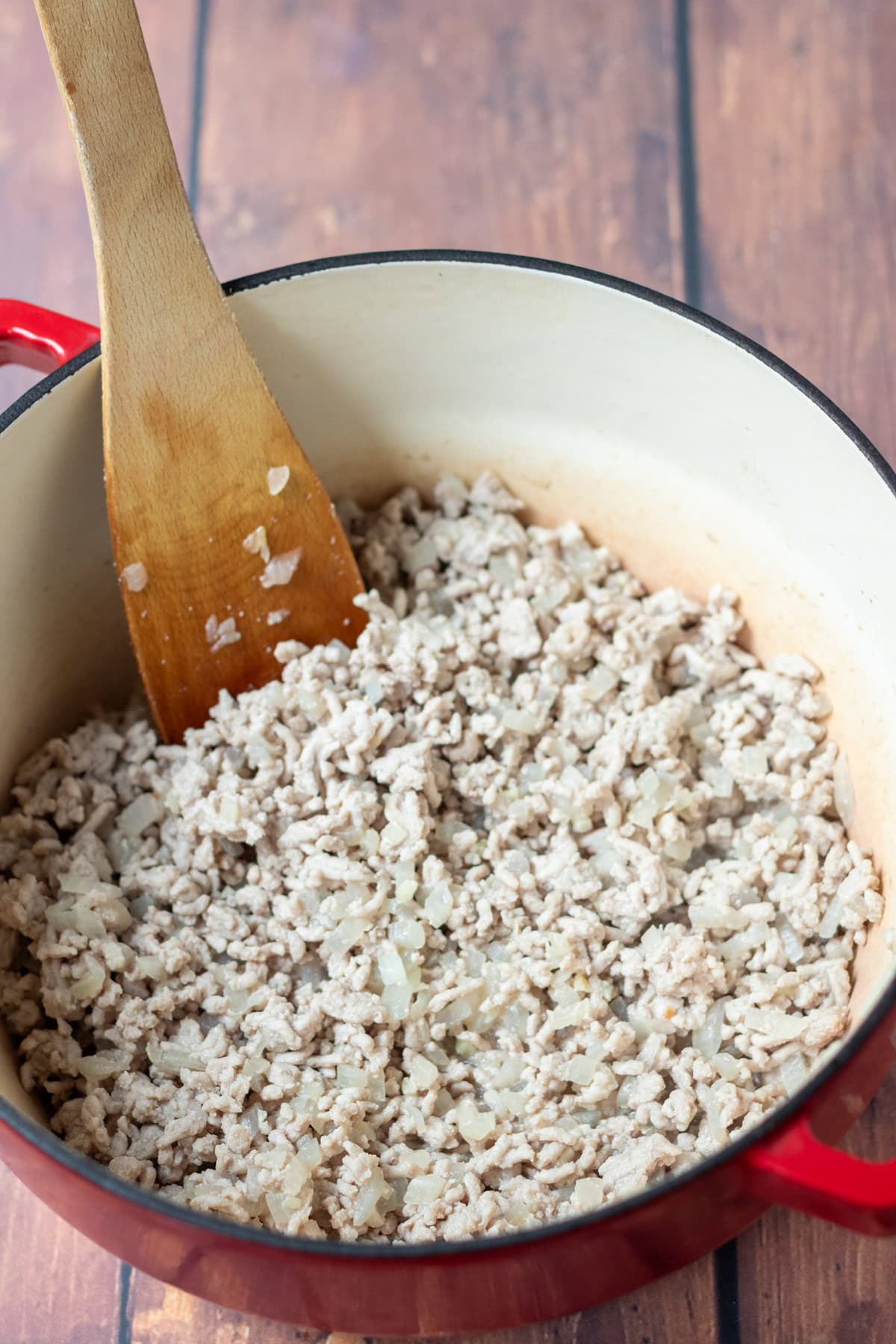 Turkey mince added to the cooked diced onion and crushed garlic in a large casserole pot.