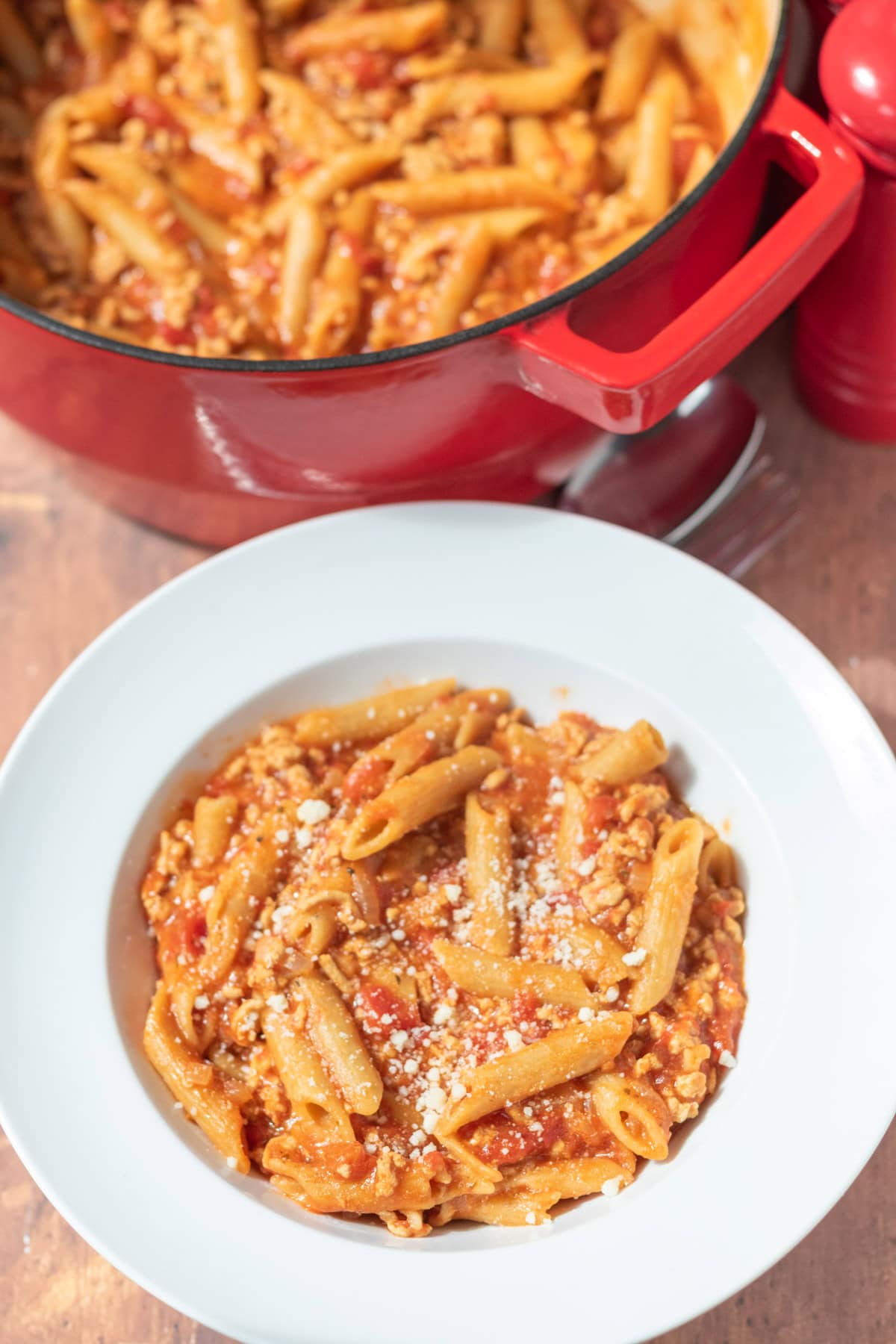 One pot turkey mince pasta served in a pasta bowl garnished with freshly grated Parmesan.